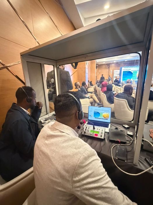 Danjire interpreters working from a glass interpretation booth overlooking the conference hall